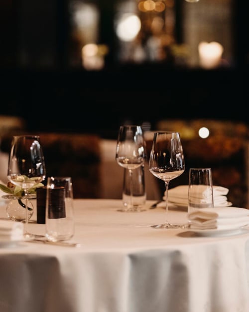 Dekket bord med hvite duker og vinglass